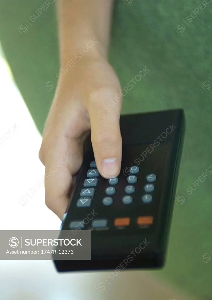 Hand pressing button on remote control