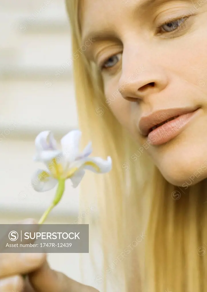 Woman looking at flower, close-up