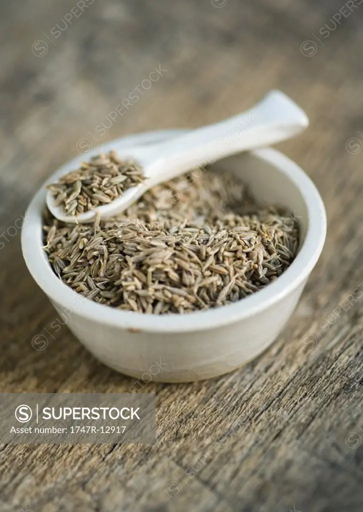 Cumin seeds in bowl, with spoon