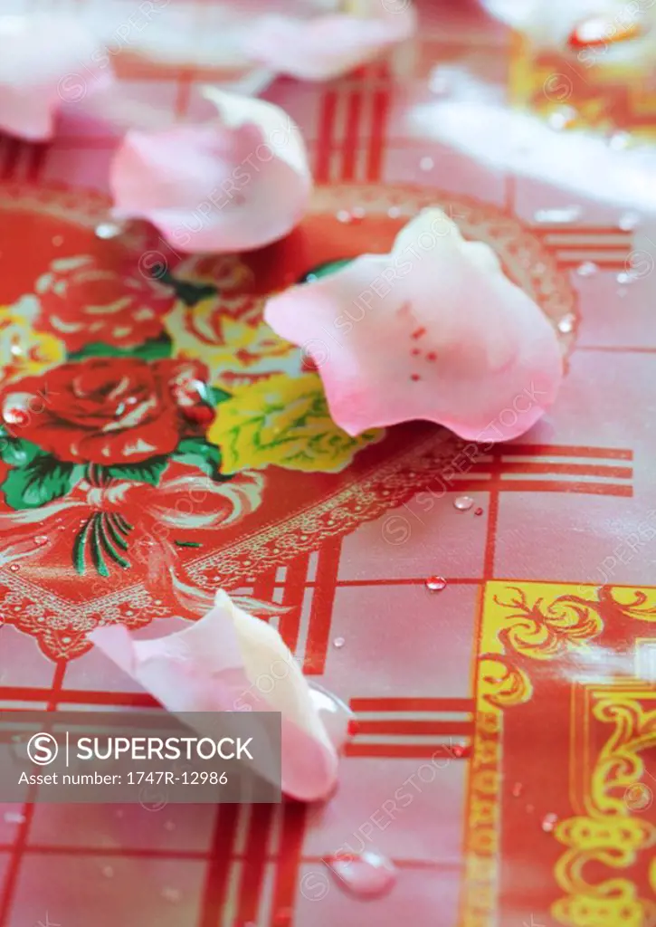 Rose petals on decorative tablecloth