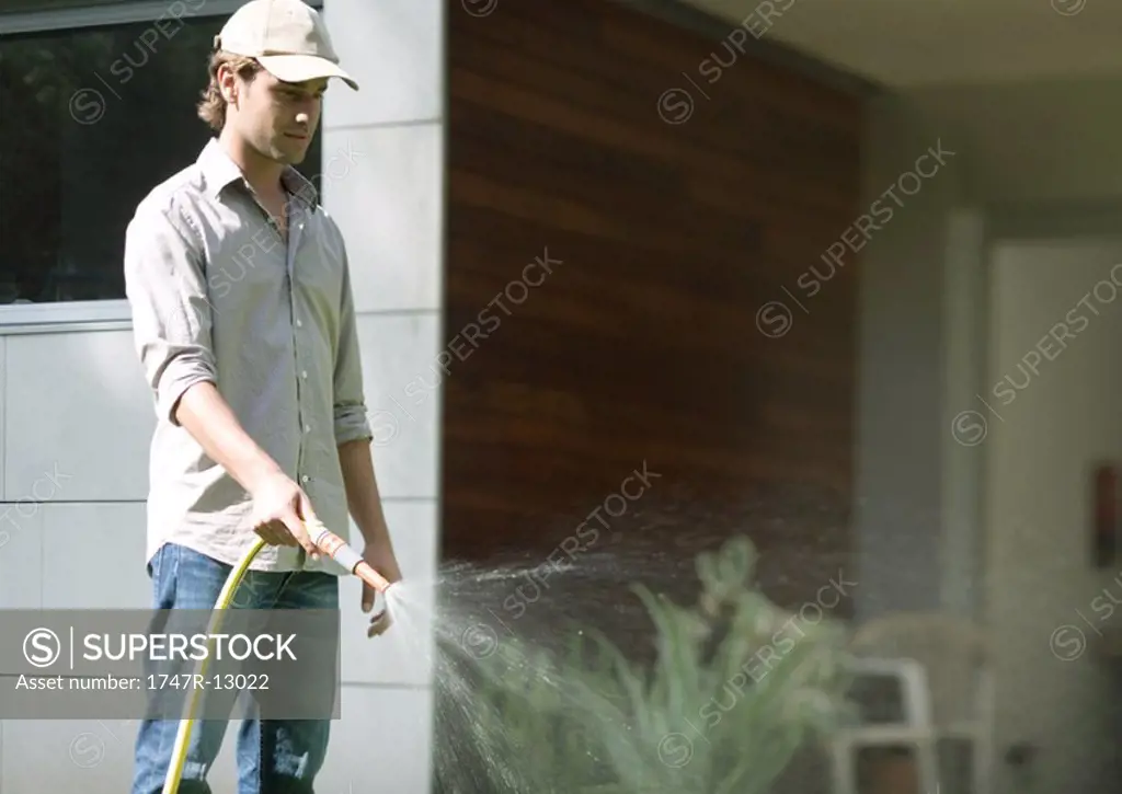 Gardener watering with hose