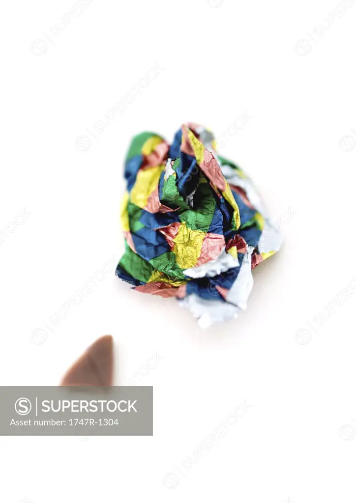 Crumpled candy wrapper and small piece of chocolate