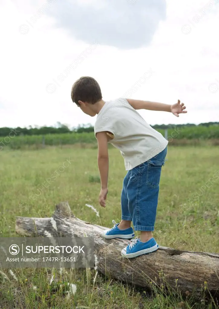 Boy standing on log