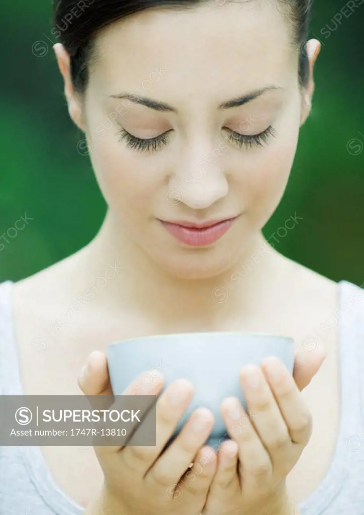 Woman holding bowl cupped in hands