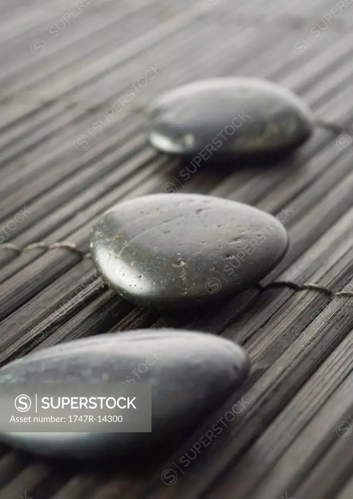 Smooth black stones on bamboo mat