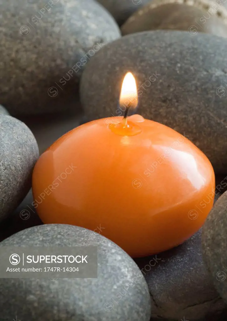 Candle burning, on stones
