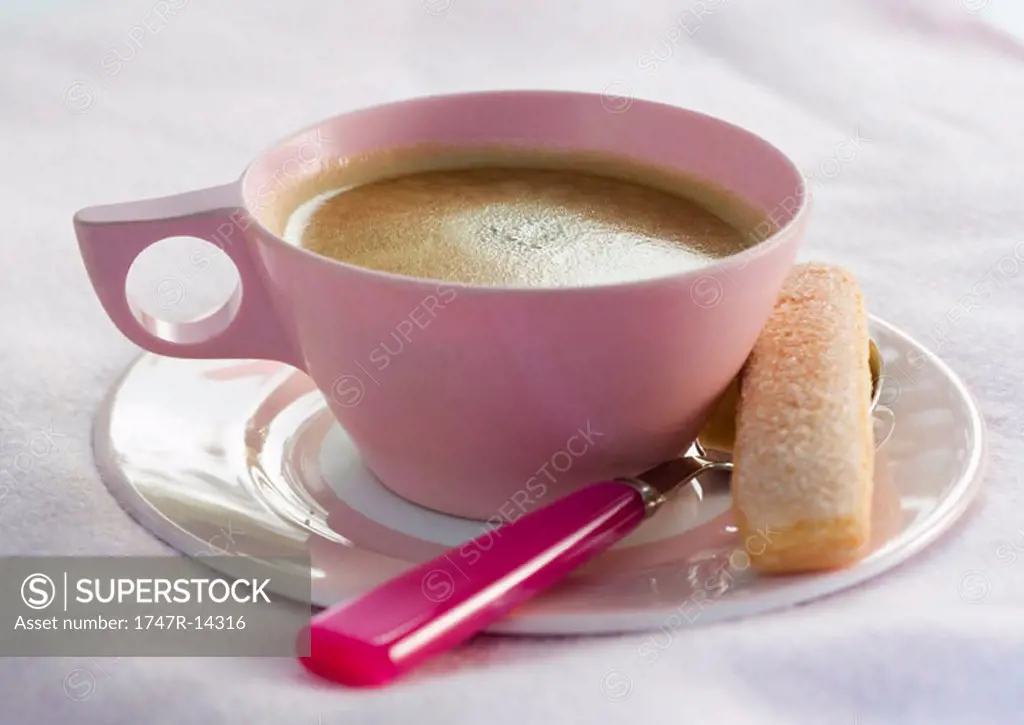 Cup of coffee with cookie and spoon on saucer