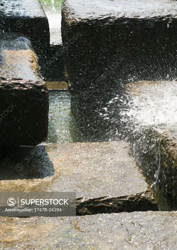 Water splashing over stones blocks, close-up