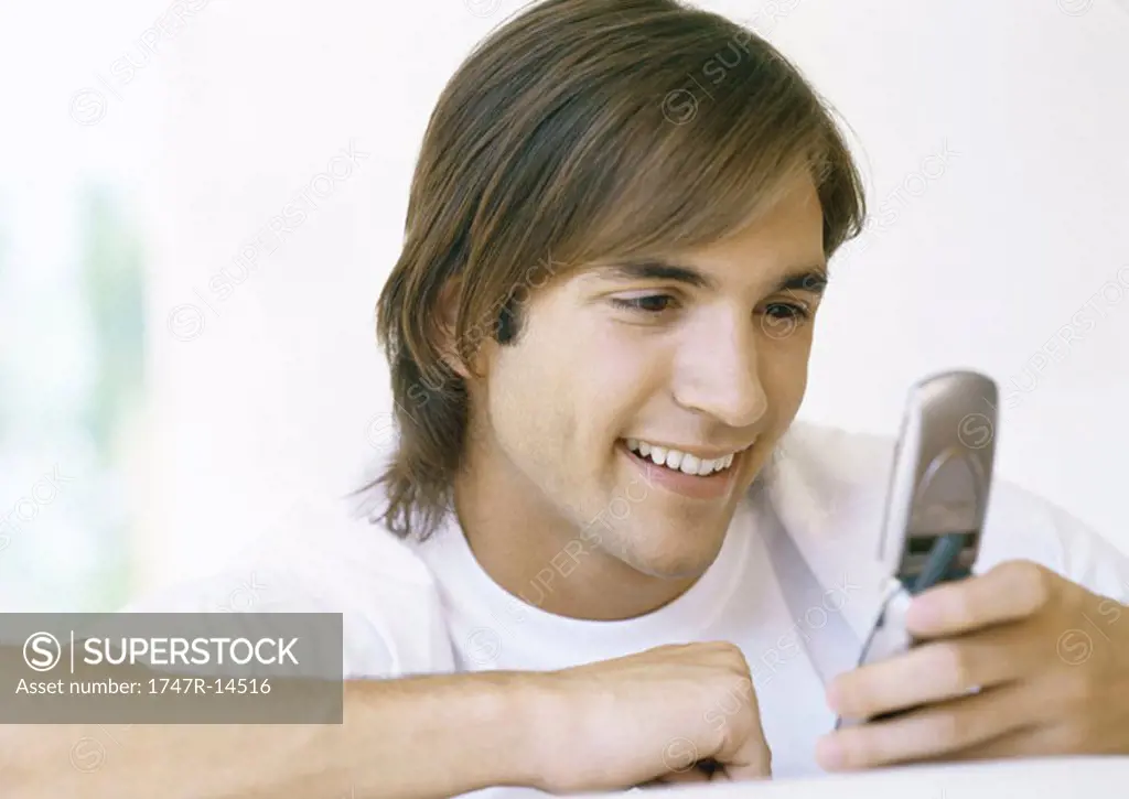 Man looking at cell phone, smiling