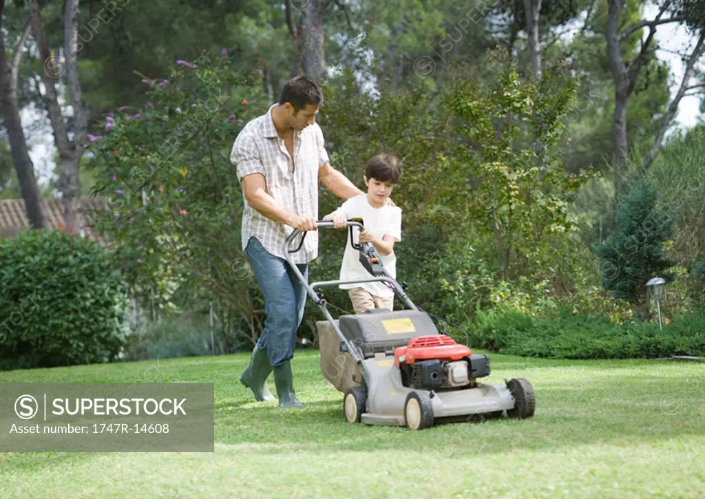 Father and son mowing lawn