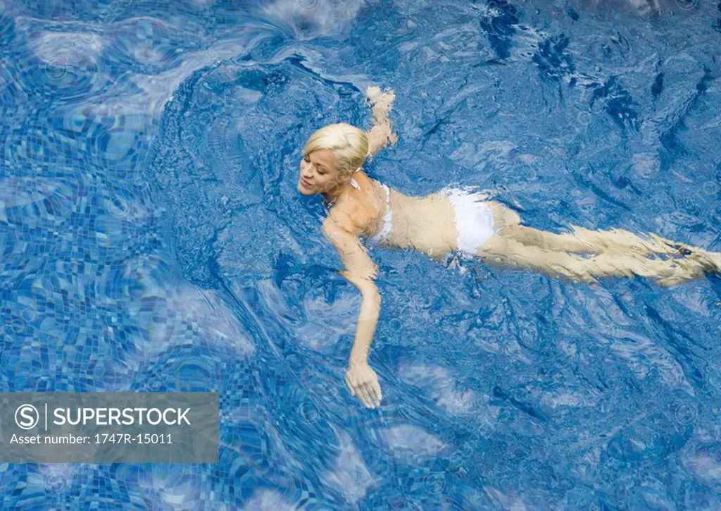 Young woman swimming in pool, high angle view