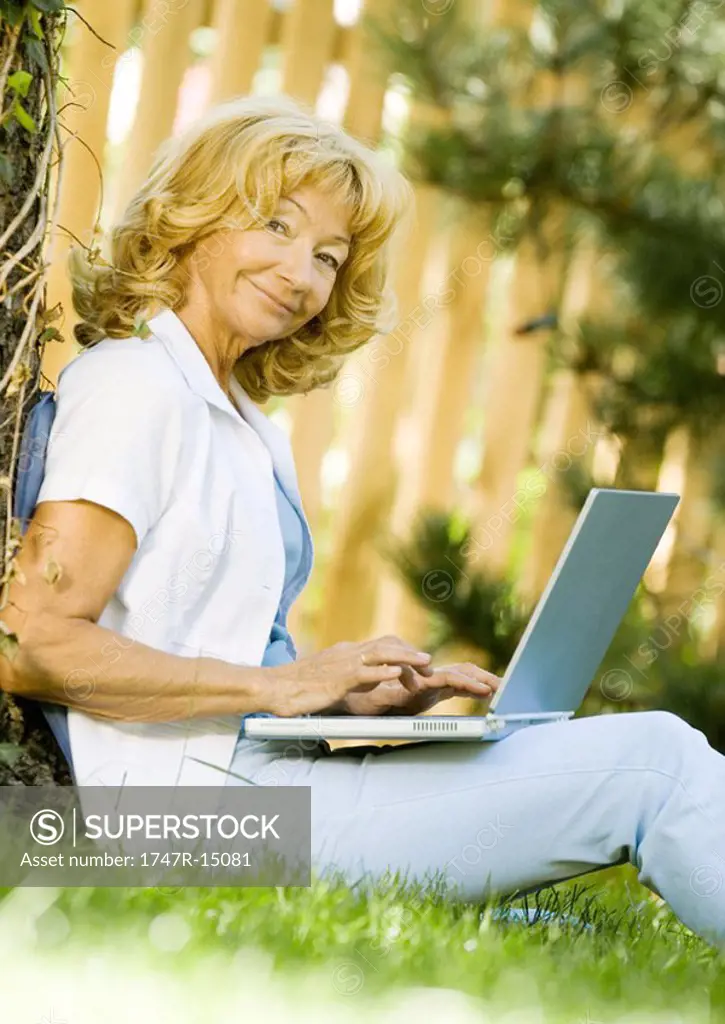 Senior woman using laptop outdoors