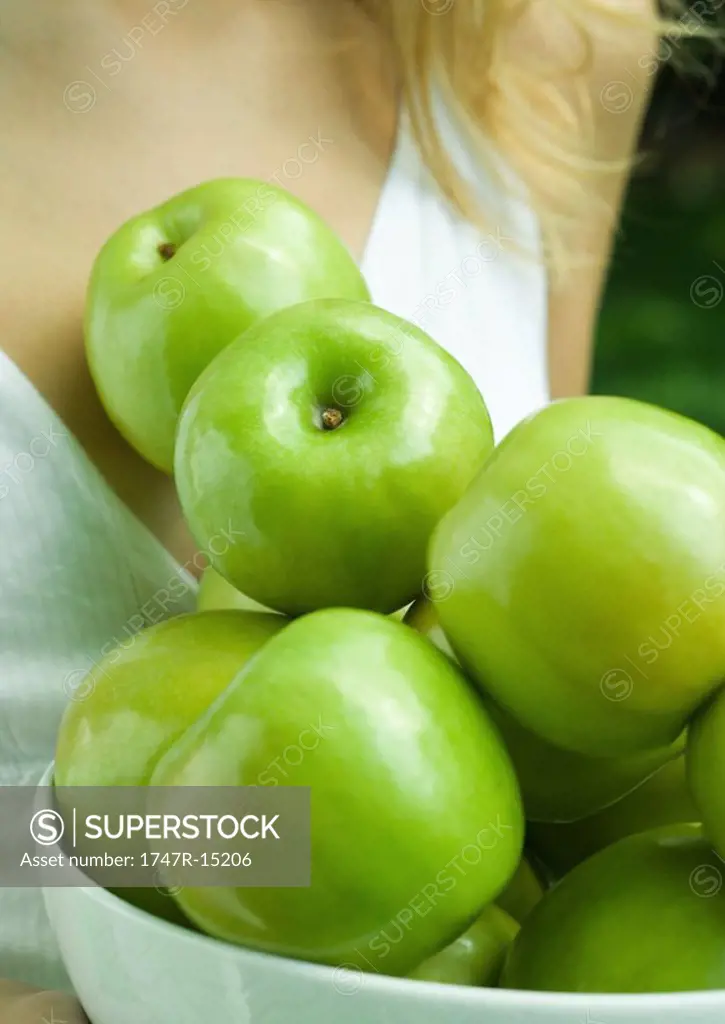 Woman holding bowl of apples, close-up of apples