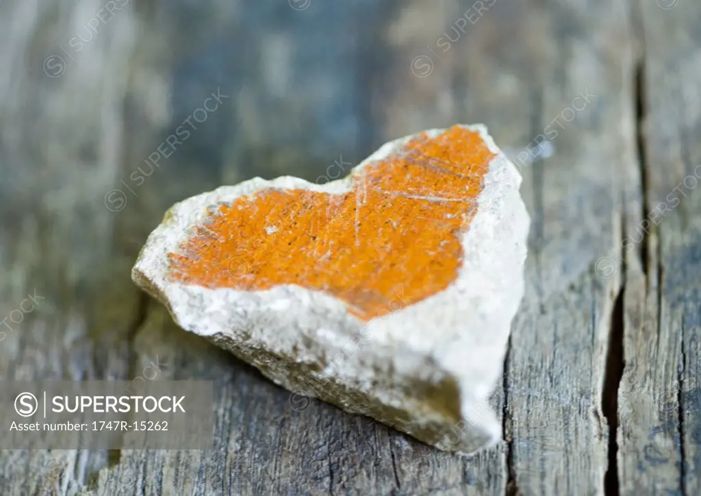 Heart shaped stone on wood surface