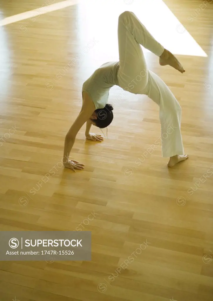 Yoga class, woman doing one-legged bridge pose