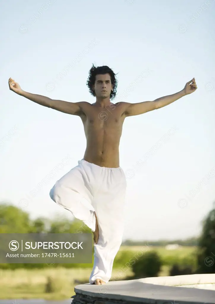 Man standing in tree pose outdoors