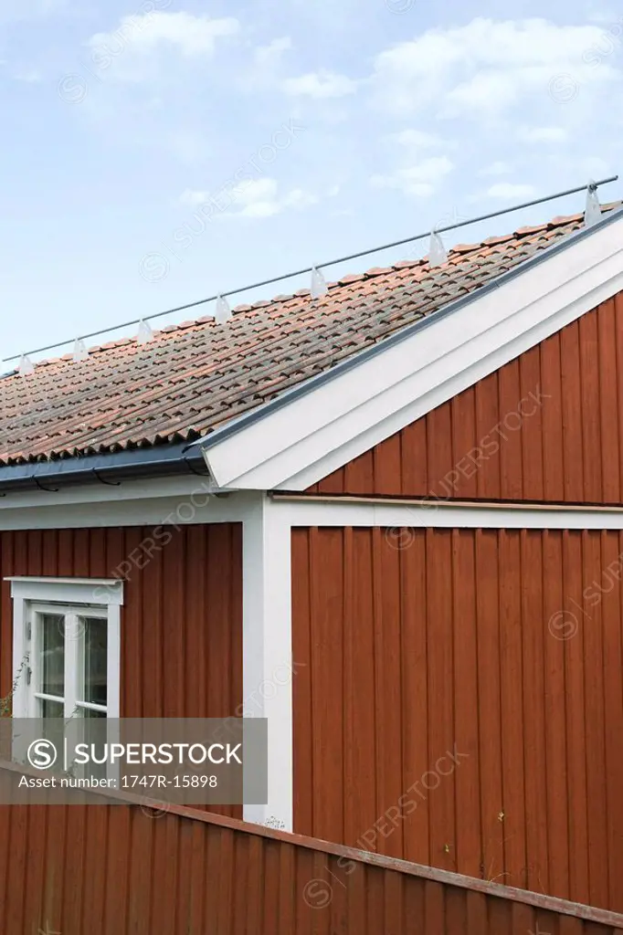 House with metal rod on roof, close-up, cropped