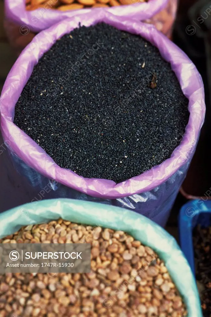 Nigella seeds and lentils in buckets, high angle view