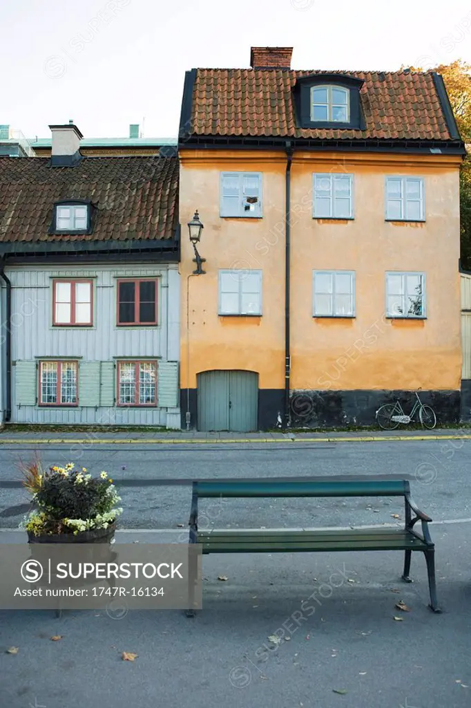 Sweden, Stockholm, bench and planter in front of rustic buildings