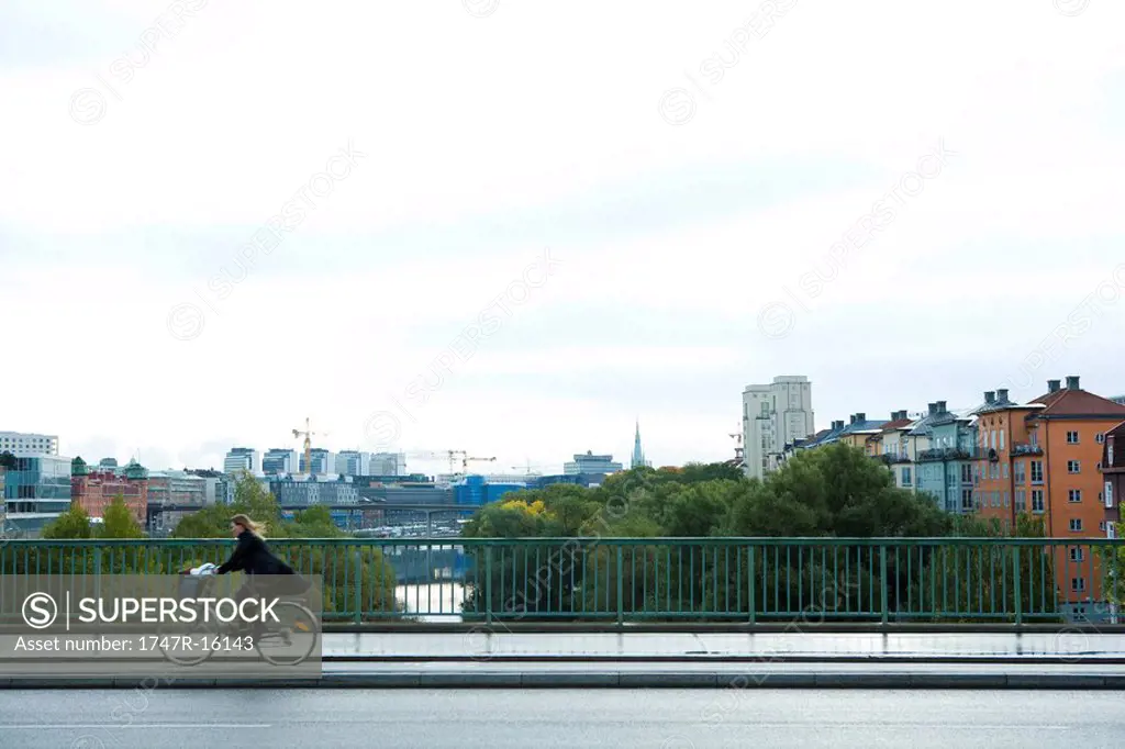 Sweden, Stockholm, bicyclist riding across bridge