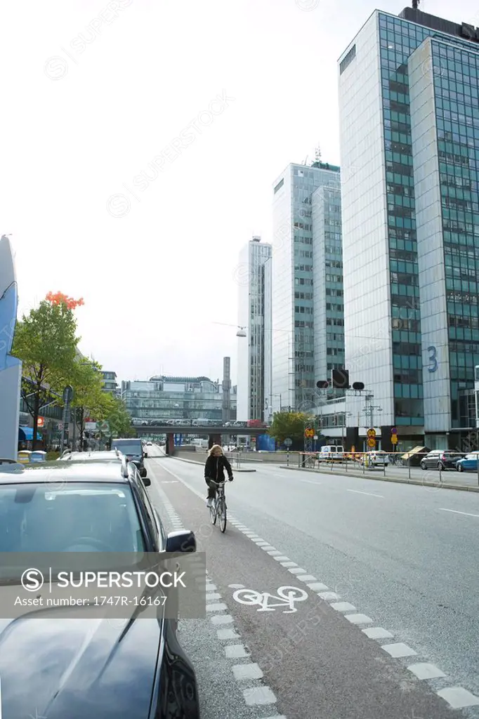 Sweden, Stockholm, bicyclist riding in urban bike lane