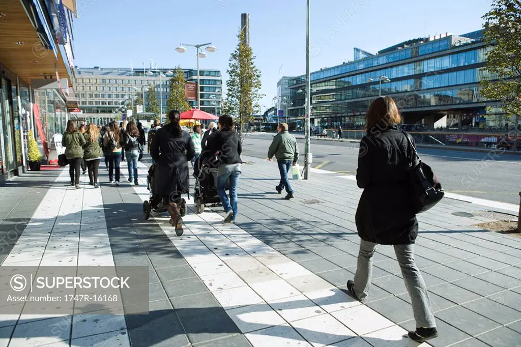 Sweden, Stockholm, pedestrians walking on wide sidewalk