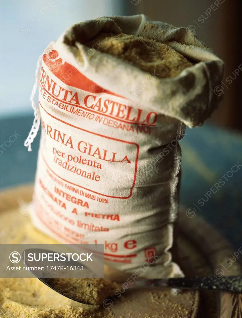 Open sack of polenta corn meal with metal scoop