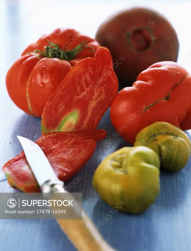 Tomatoes, one sliced with paring knife