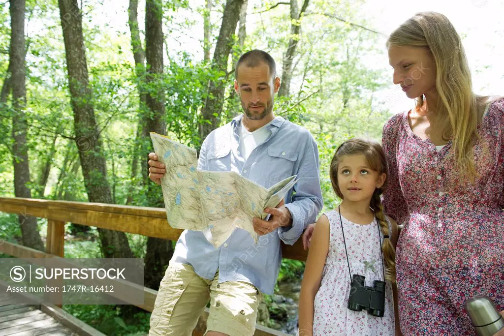 Family pausing in woods to consult map