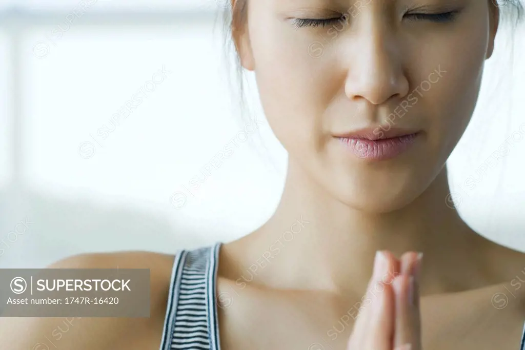 Young woman meditating in prayer position
