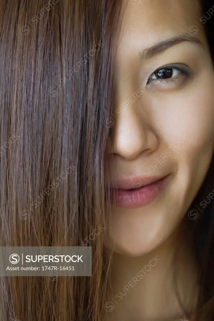 Young woman with hair covering half of face