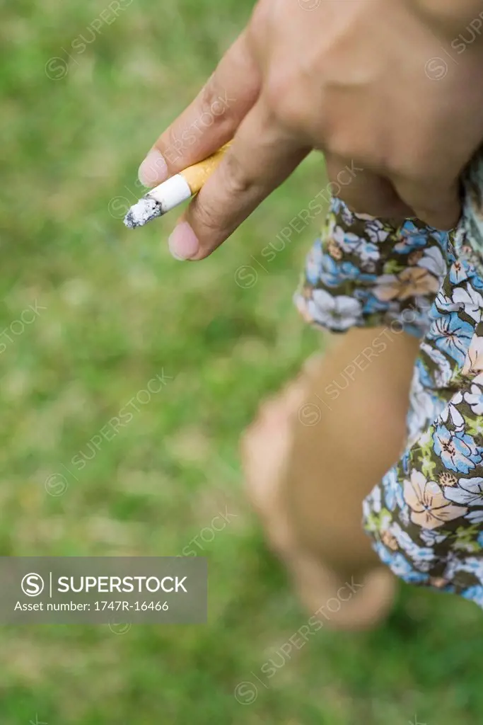 Woman´s hand holding cigarette, cropped