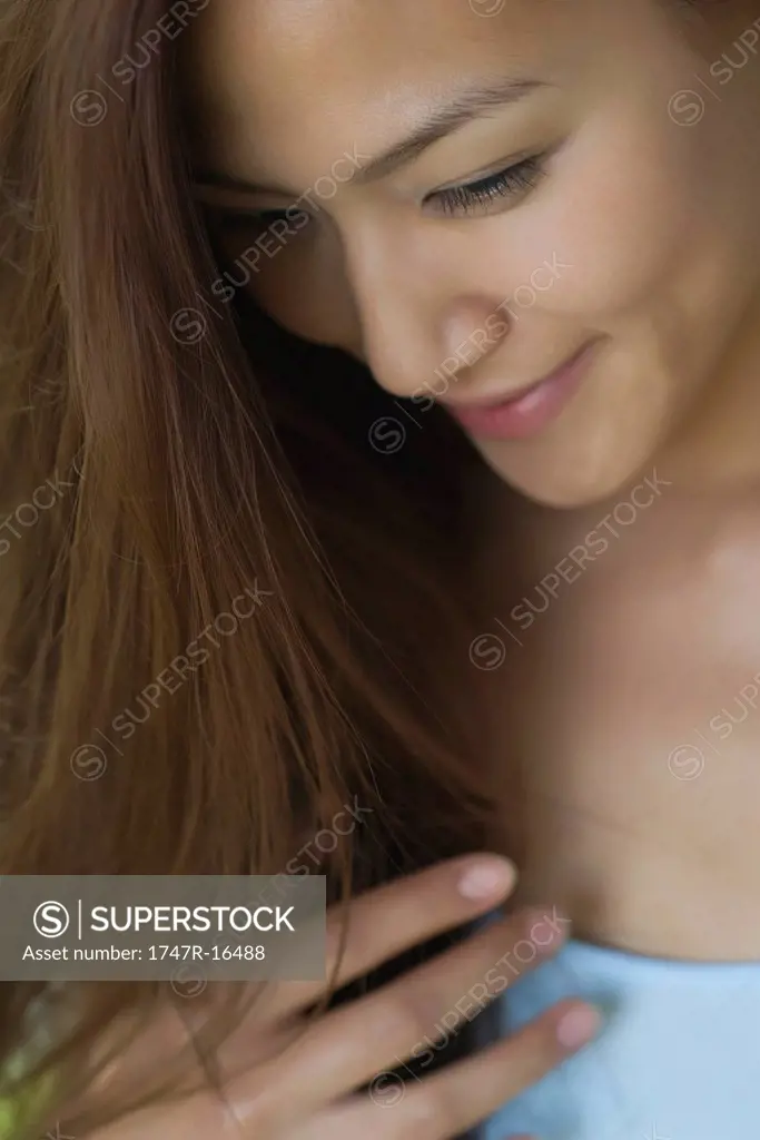Smiling young woman looking down