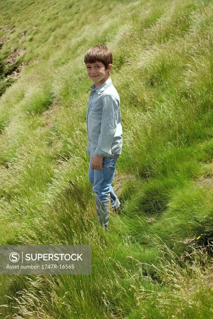 Boy walking on hillside, portrait