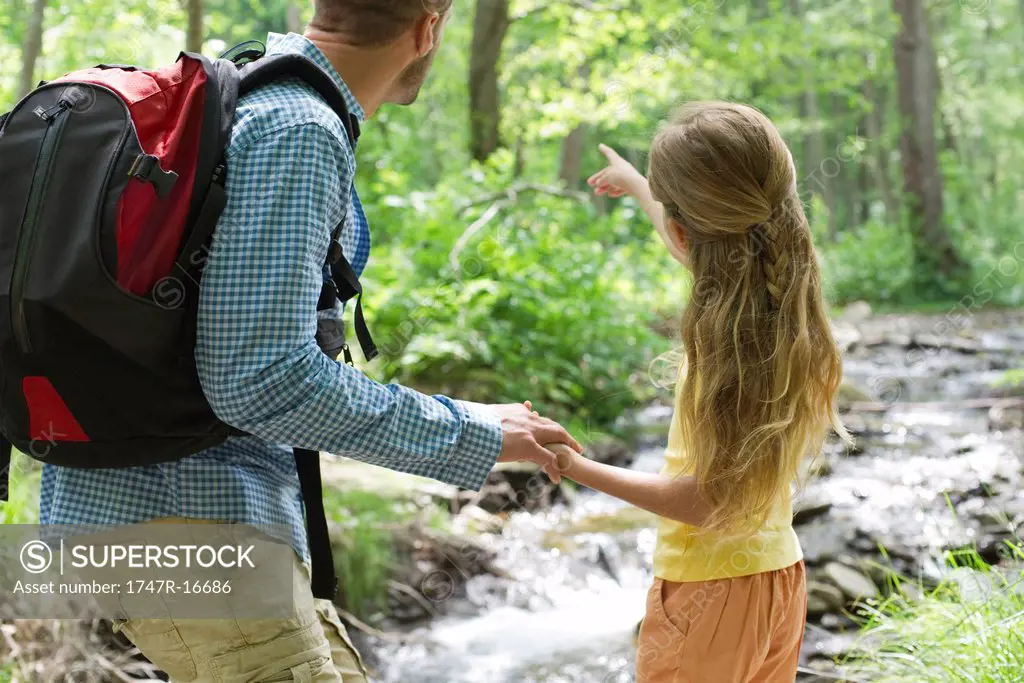 Father and daughter hiking in woods together