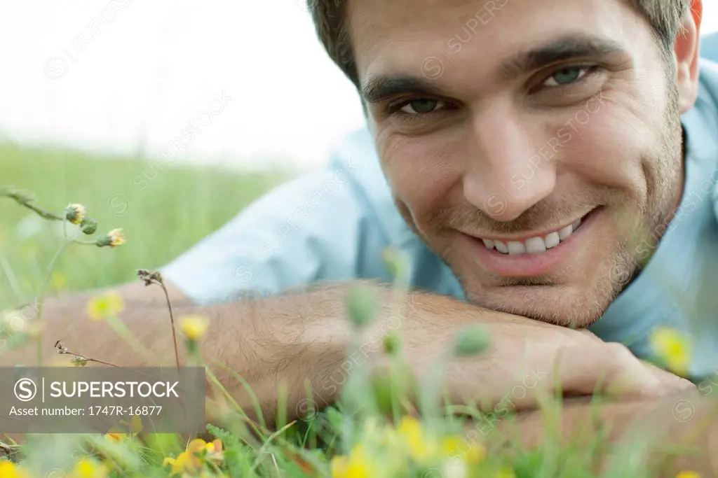 Man relaxing on meadow, cropped