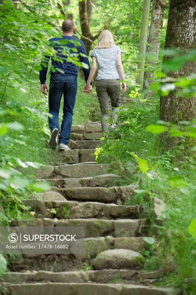 Couple walking up stone steps in woods