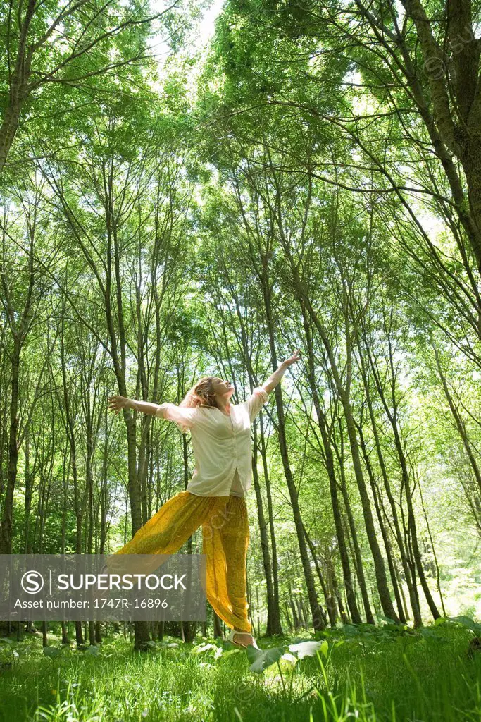 Young woman jumping in woods