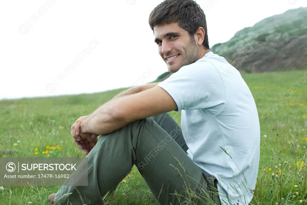 Man sitting on meadow, portrait