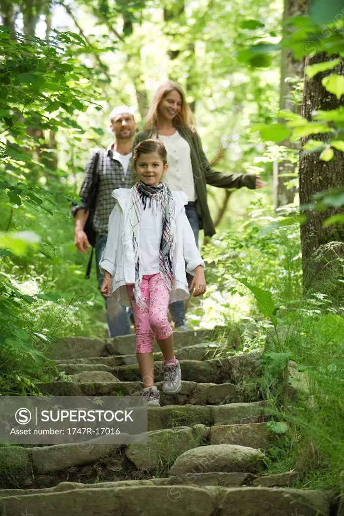 Family walking down steps in woods