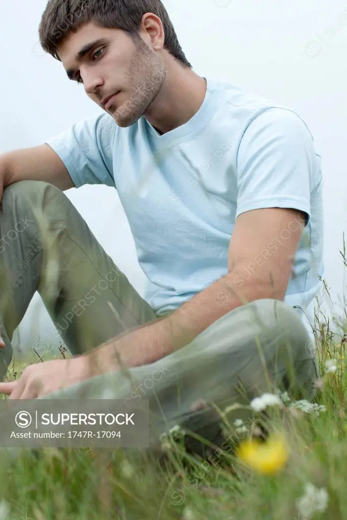 Man sitting on meadow in thought