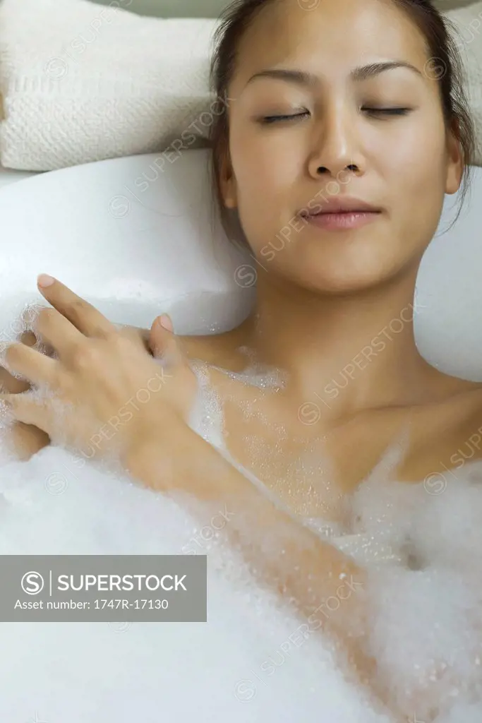 Young woman taking bubble bath