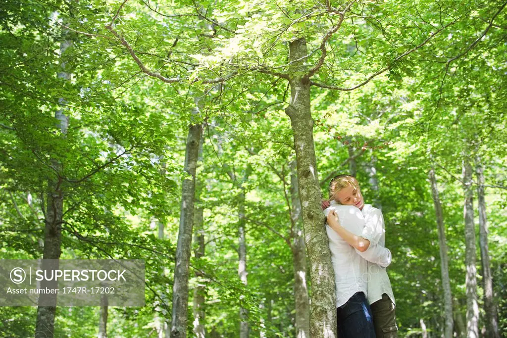 Couple embracing in woods