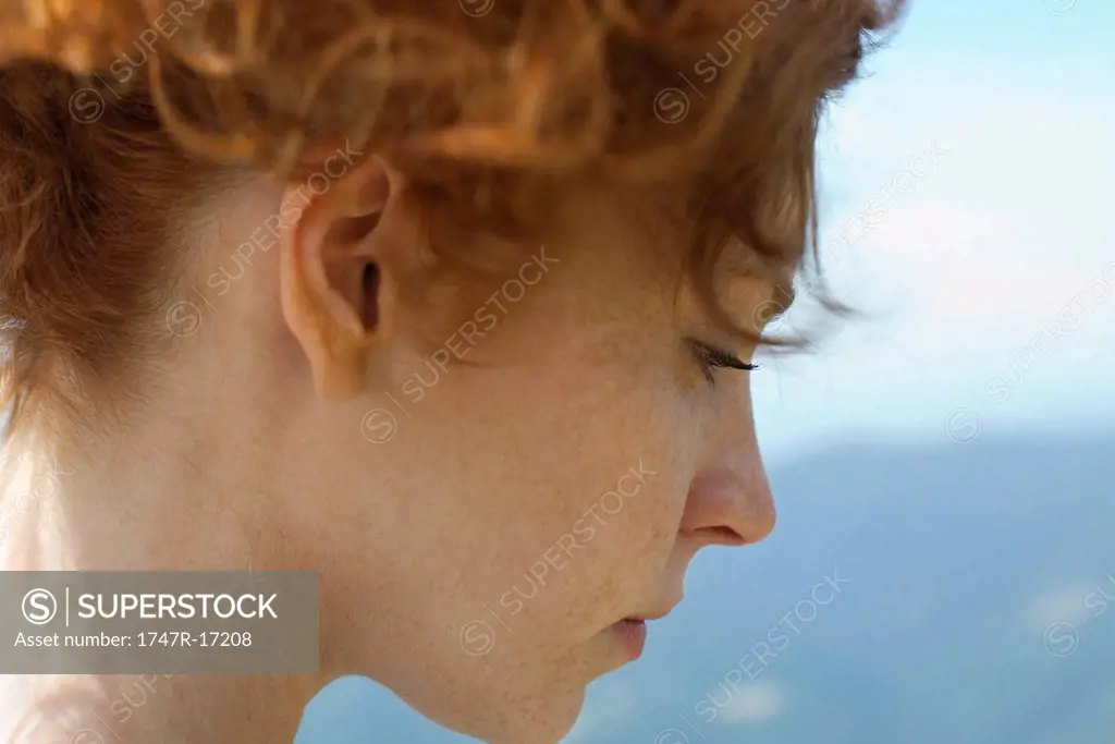 Redheaded woman with hair up, side view
