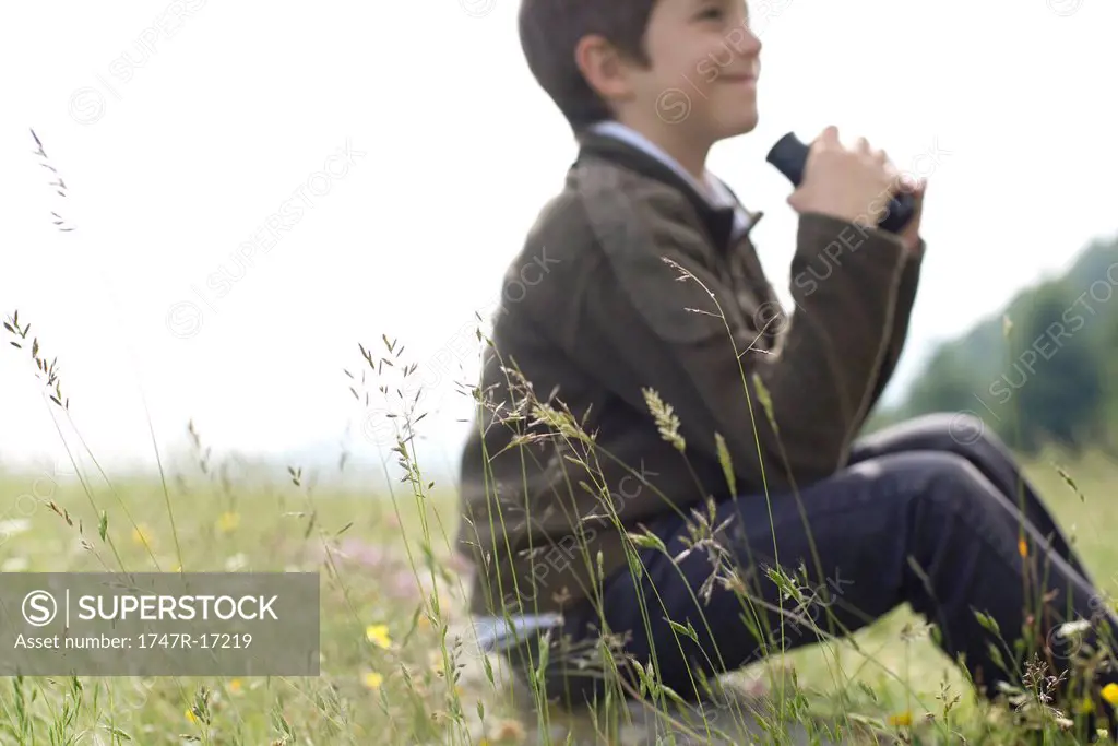 Boy sitting in tall grass