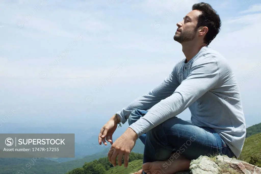 Man meditating on hilltop