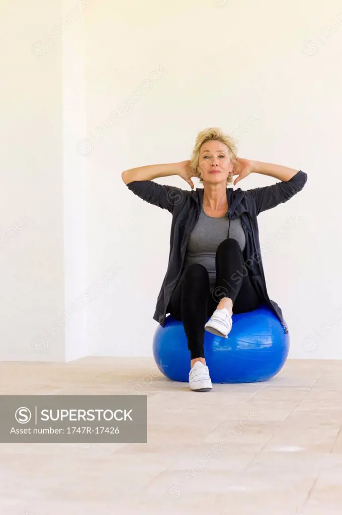 Mature woman exercising on fitness ball