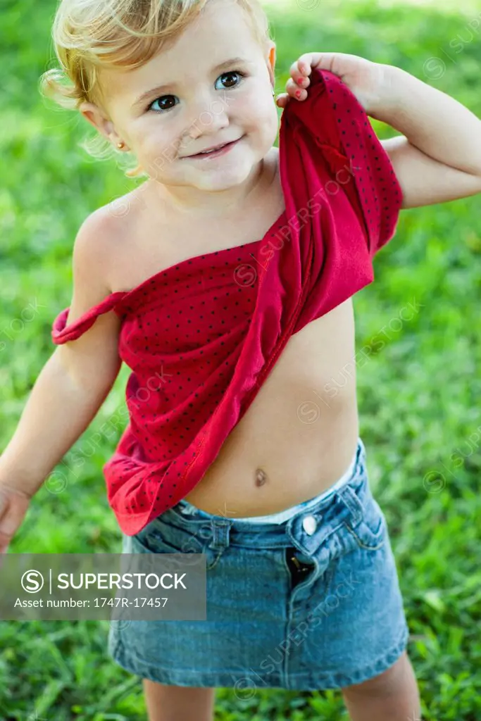 Baby girl lifting shirt up, portrait