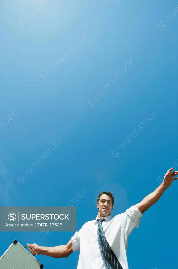 Mid_adult businessman carrying briefcase, low angle view