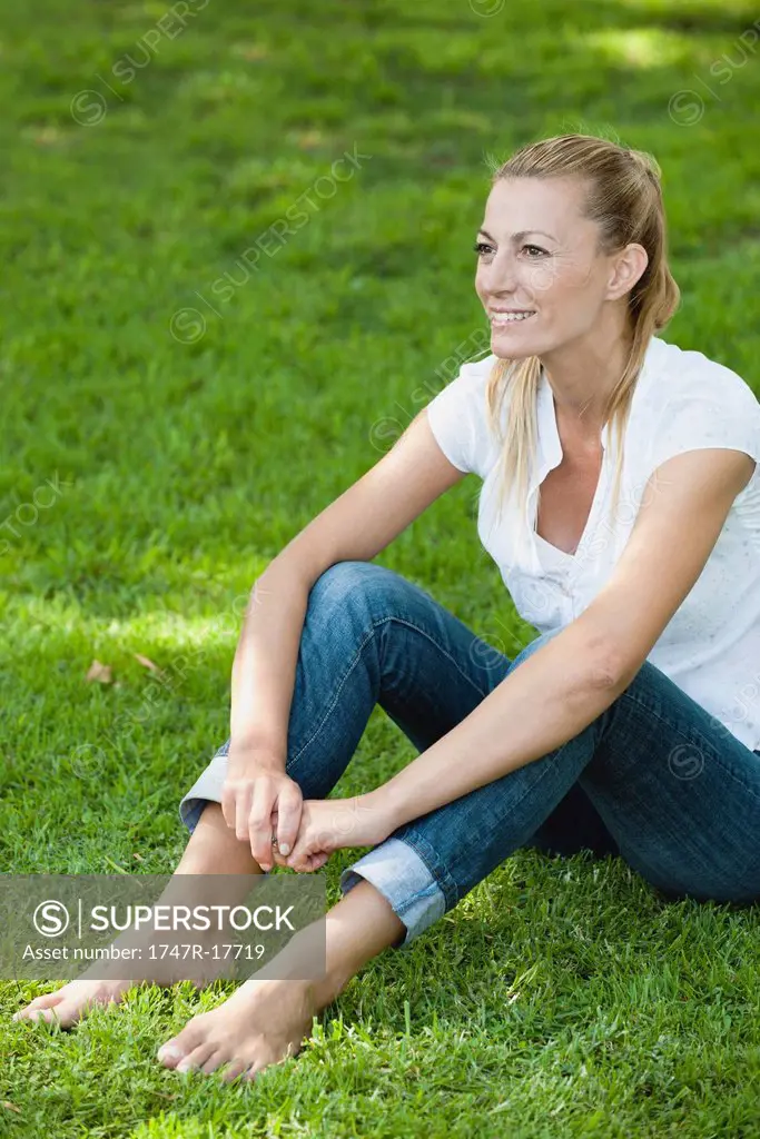 Mature woman relaxing on grass